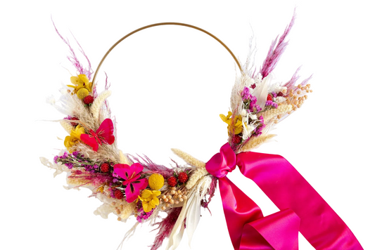 Clementine Wreath: a gold hoop with one side covered in yellow, cream, and bright pink flowers with a hot pink ribbon