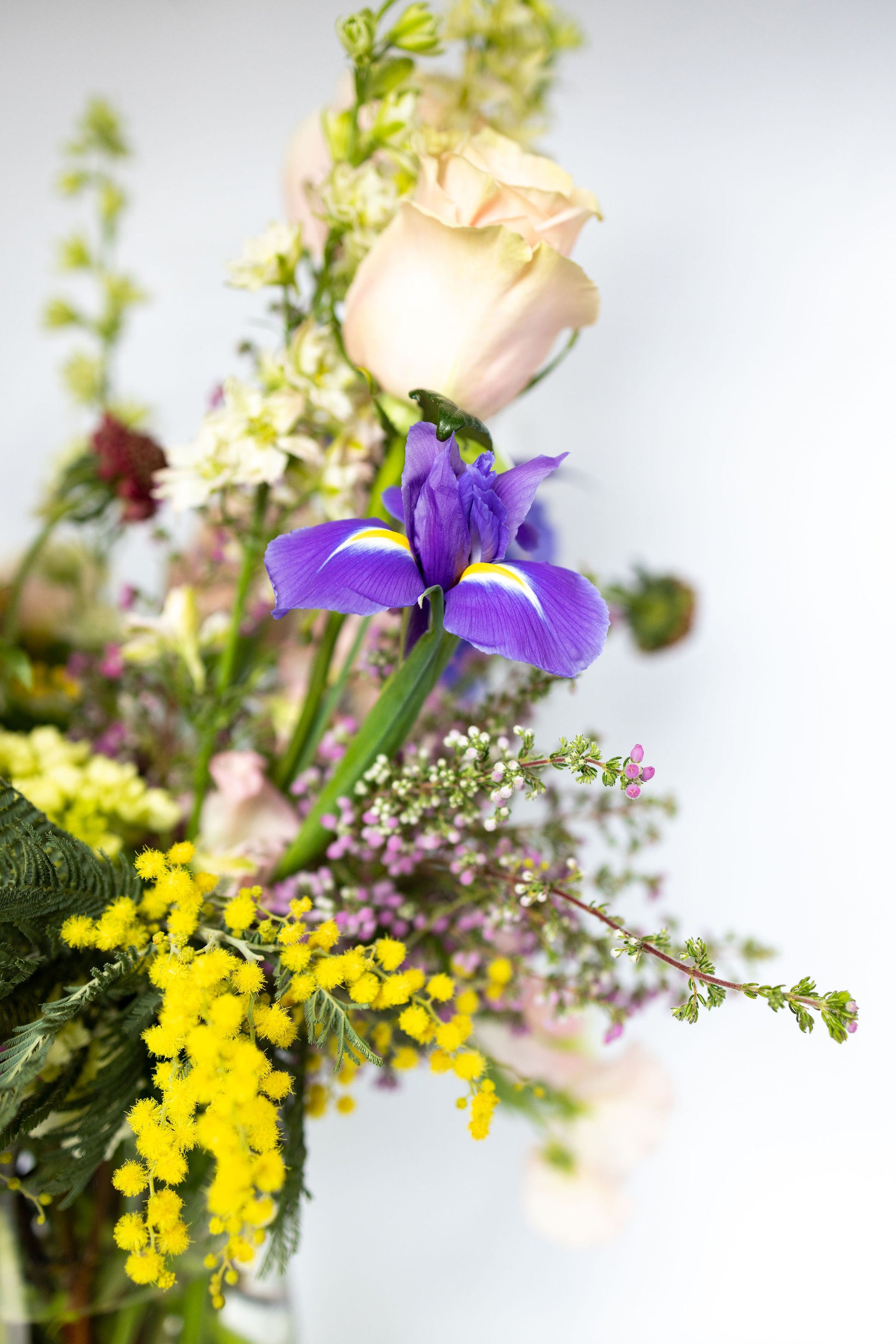 Bouquet of flowers in sunshine yellows, light blushes, and vibrant violets