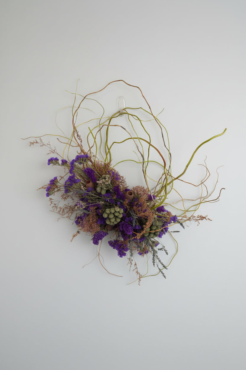 Decorative wreath with purple and green elements against a tiled wall.