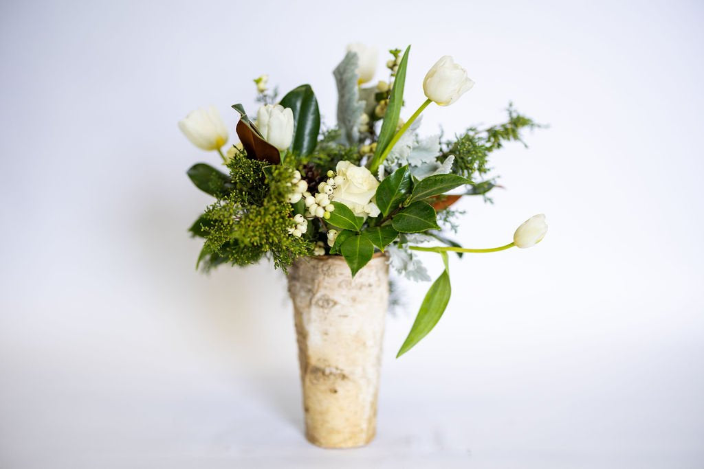Buttercream floral arrangement in a wooden vase on a light background